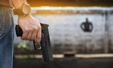 9 mm 'lik tabanca, elinde silah tutan, yumuşak ve seçici odaklı..