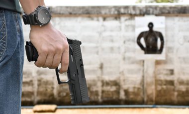9 mm 'lik tabanca, elinde silah tutan, yumuşak ve seçici odaklı..