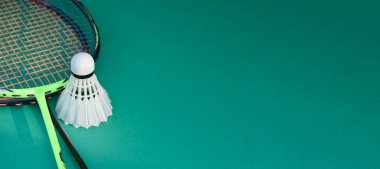 Badminton raketleri ve beyaz kremalı badminton mekikleri oynadıktan sonra veya kapalı badminton sahasının mavi zemininde oynadıktan sonra, dünya çapında badminton severler için yumuşak odak, konsept.