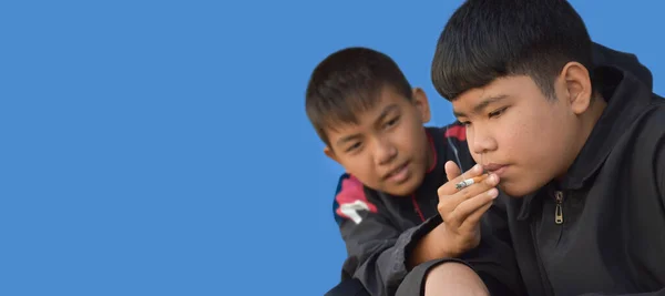 Siyah Tişörtlü Asyalı Çocuk Arkadaşıyla Sigara Içmeye Çalışıyor Mavi Arka — Stok fotoğraf