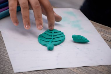 Playdough or plasticine molding activity of the asian special needed boys at home by parents to increase brain skills concept, soft and selective focus. clipart