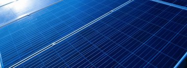 Photovoltaic or photoelectric rooftop which has the reflection of the Sun and clouds on the surface, cropped shot.