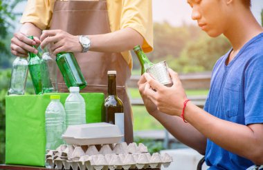 Genç yakışıklı Asyalı eşcinsel çiftler evlerinin önünde, evlerini, şişelerini, kutularını, çöplerini, kağıtlarını, yumurta tepsilerini ve küresel ısınma kavramlarını ayırıyorlar..