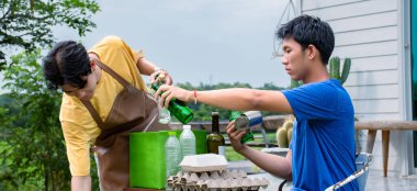 Genç yakışıklı Asyalı eşcinsel çiftler evlerinin önünde, evlerini, şişelerini, kutularını, çöplerini, kağıtlarını, yumurta tepsilerini ve küresel ısınma kavramlarını ayırıyorlar..