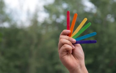 Gökkuşağı renginde dondurma çubukları Asyalı çocuğun ellerinde, yumuşak ve seçici odaklanma, tüm insanları LGBT etkinliklerini ve dünya çapında kampanyaları desteklemeye çağırma konsepti.