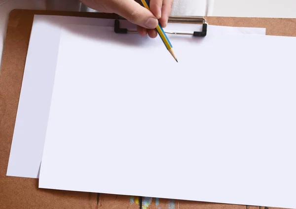 Mains Tenant Crayon Sur Papier Blanc Vierge Pour Écrire Dessiner Image En Vente