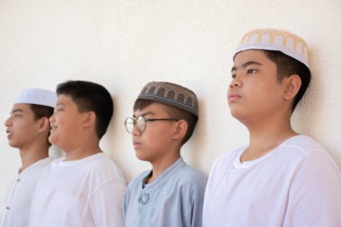 Asyalı Müslüman ya da İslamcı çocukların yerel cami önünde durup dini faaliyet için bekledikleri ön görüş, yumuşak ve seçici odaklanma.