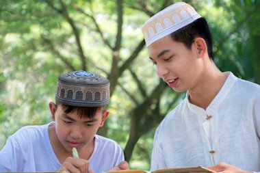 Asyalı Müslüman ya da İslamcı çocuklar boş zamanlarını okulda dini aktivitelere katılmadan önce ev ödevlerine yardım ederek geçiriyorlar. Tüm dinlerin çocukluğu, yumuşak odaklanma..