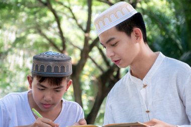Asyalı Müslüman ya da İslamcı çocuklar boş zamanlarını okulda dini aktivitelere katılmadan önce ev ödevlerine yardım ederek geçiriyorlar. Tüm dinlerin çocukluğu, yumuşak odaklanma..
