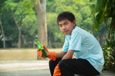 Asyalı çocuk çöplükteki cam ve plastik şişeleri geri dönüşüm için plastik poşetlere dönüştürüyor ya da satıyor. Günlük hayatı için para kazanmak için. Yeni düzenleme, çevre bakımı konsepti..
