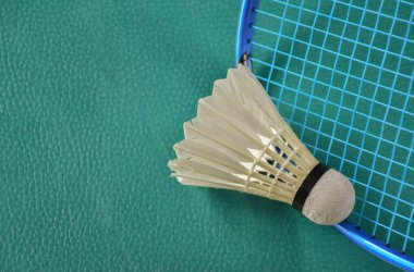 Beyaz badminton topu ve raketler kapalı badminton kortunda, kopyalama alanı, mekik horozlarına yumuşak ve seçici odaklanma.