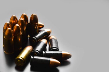 Gri arka planda 9mm 'lik tabanca mermileri, yumuşak odaklanma, yeni düzenleme, spor çekme konsepti ve dünya çapında insan hayatını ve mülkünü korumak için eğitim kavramı.