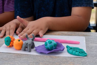 Ahşap masada plastik ellerle oynayan çocukların yakın çekimleri