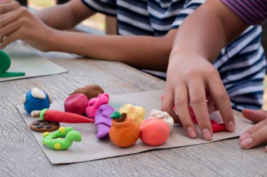 Ahşap masada plastik ellerle oynayan çocukların yakın çekimleri