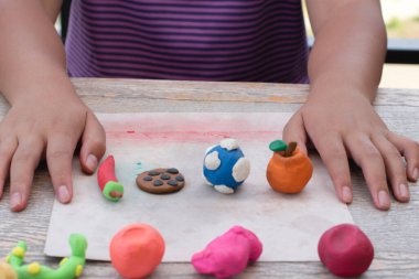 Ahşap masada plastik ellerle oynayan çocukların yakın çekimleri