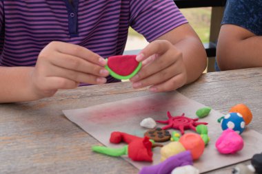 Ahşap masada plastik ellerle oynayan çocukların yakın çekimleri