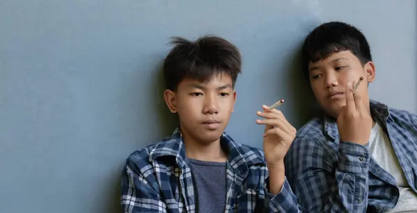 Asiatique Garçon Tenait Briquet Allumer Fin Une Cigarette Pour Essayer Photo De Stock