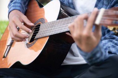 Yakın çekim el ve parmaklar akustik gitar, eğlence aktivitesi, hobi ve serbest stil çalmayı seven insanların popüler enstrümanları.