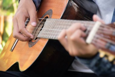 Yakın çekim el ve parmaklar akustik gitar, eğlence aktivitesi, hobi ve serbest stil çalmayı seven insanların popüler enstrümanları.