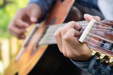 Yakın çekim el ve parmaklar akustik gitar, eğlence aktivitesi, hobi ve serbest stil çalmayı seven insanların popüler enstrümanları.