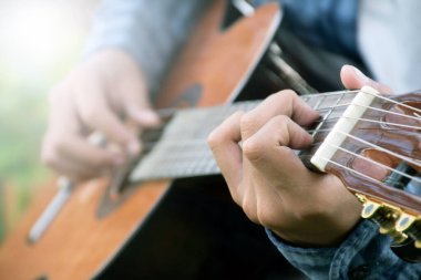 Yakın çekim el ve parmaklar akustik gitar, eğlence aktivitesi, hobi ve serbest stil çalmayı seven insanların popüler enstrümanları.