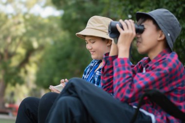 Asyalı çocuklar parklarındaki kuşları dürbünle izleyerek rahatlıyorlar..