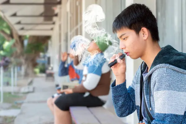 Asiatique Garçon Fumant Cigarette Devant Mur Non Loin Ses Frites Images De Stock Libres De Droits