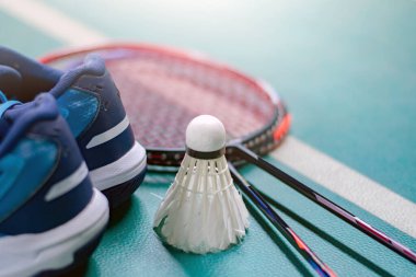 Badminton spor malzemeleri, raketler, mekik horozları, ayakkabılar, kapalı badminton kortunun pvc zemininde egzersiz yapmak için, yumuşak odak, tüm dünyada badminton oynamak için konsept.