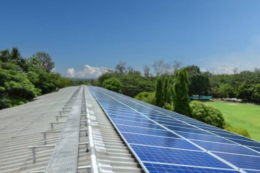 Uzak bir okulun çatısındaki güneş panelleri sürdürülebilir bir enerji çözeltisi sağlayarak elektrik maliyetlerini düşürür ve çevre bilincini artırır. Çevre dostu kavramı.