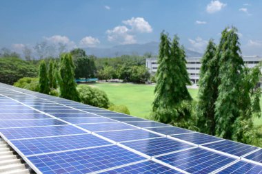Uzak bir okulun çatısındaki güneş panelleri sürdürülebilir bir enerji çözeltisi sağlayarak elektrik maliyetlerini düşürür ve çevre bilincini artırır. Çevre dostu kavramı.
