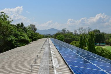 Uzak bir okulun çatısındaki güneş panelleri sürdürülebilir bir enerji çözeltisi sağlayarak elektrik maliyetlerini düşürür ve çevre bilincini artırır. Çevre dostu kavramı.