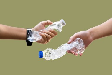 İzole edilmiş boş ve bükülmüş plastik su şişeleri kırpma yollarıyla el ele tutuşuyor, çevre dostu ve çevresel bakım kavramı.