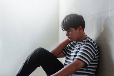 Asyalı genç, kilitli bir kapının metal çitlerini tutuyor ve ailesi tarafından cezalandırıldıktan sonra özgürlük istiyor. Çocuk özgürlüğü kavramı..
