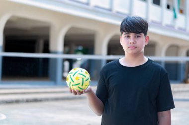 Sepak takunyalı top, Güneydoğu Asya ülkeleri geleneksel spor, genç sepak takham oyuncusunu kalenin önünde tutarken topu başka bir oyuncuya atıyor..