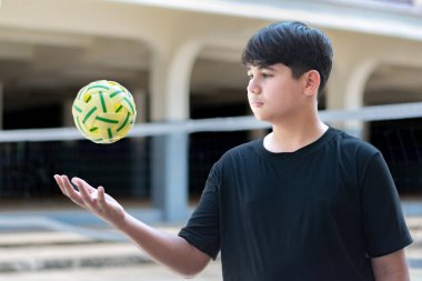 Sepak takunyalı top, Güneydoğu Asya ülkeleri geleneksel spor, genç sepak takham oyuncusunu kalenin önünde tutarken topu başka bir oyuncuya atıyor..