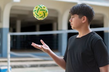 Sepak takunyalı top, Güneydoğu Asya ülkeleri geleneksel spor, genç sepak takham oyuncusunu kalenin önünde tutarken topu başka bir oyuncuya atıyor..