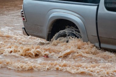 Şiddetli yağışlı bir mevsim nedeniyle çamurlu yağmurlar bölgeyi birbirine bağlayan ana yolları sular altında bıraktı, arabaların geçmesini zorlaştırdı ve motor arızalarına yol açtı, hareket halinde, araba sigortası konsepti, hareket halinde.