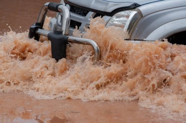 Şiddetli yağışlı bir mevsim nedeniyle çamurlu yağmurlar bölgeyi birbirine bağlayan ana yolları sular altında bıraktı, arabaların geçmesini zorlaştırdı ve motor arızalarına yol açtı, hareket halinde, araba sigortası konsepti, hareket halinde.