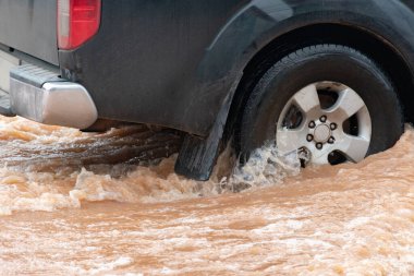 Şiddetli yağışlı bir mevsim nedeniyle çamurlu yağmurlar bölgeyi birbirine bağlayan ana yolları sular altında bıraktı, arabaların geçmesini zorlaştırdı ve motor arızalarına yol açtı, hareket halinde, araba sigortası konsepti, hareket halinde.