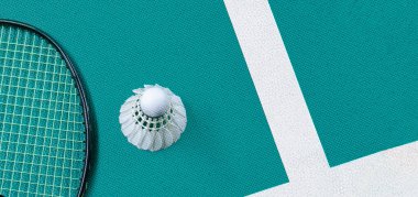 Beyaz badminton topu ve raketi kapalı badminton kortunda, kopyalama alanı, mekik horozlarına yumuşak ve seçici odaklanma.