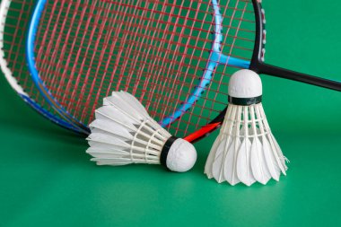 Badminton spor ekipmanları, raket ve beyaz krem rengi mekiks tüyü top yerde, yumuşak ve seçici odaklanma.