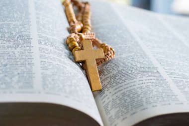 Açılmış sayfa kitabına tahta haç, yumuşak odak, Hıristiyanlık rahiplerinin İncil çalışması konsepti..