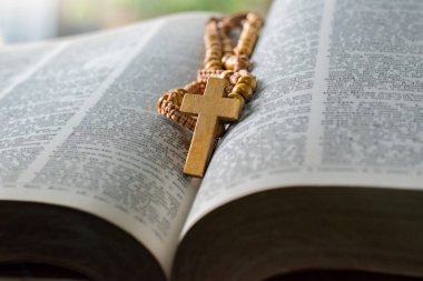 Açılmış sayfa kitabına tahta haç, yumuşak odak, Hıristiyanlık rahiplerinin İncil çalışması konsepti..
