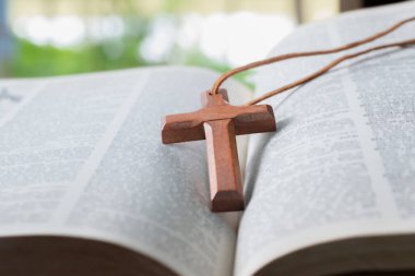 Açılmış sayfa kitabına tahta haç, yumuşak odak, Hıristiyanlık rahiplerinin İncil çalışması konsepti..