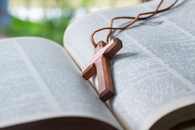Açılmış sayfa kitabına tahta haç, yumuşak odak, Hıristiyanlık rahiplerinin İncil çalışması konsepti..