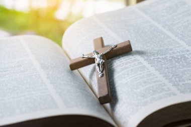 Açılmış sayfa kitabına tahta haç, yumuşak odak, Hıristiyanlık rahiplerinin İncil çalışması konsepti..