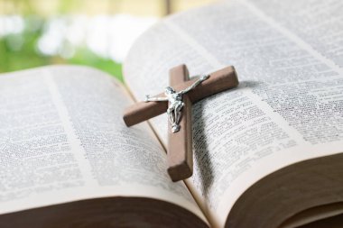 Açılmış sayfa kitabına tahta haç, yumuşak odak, Hıristiyanlık rahiplerinin İncil çalışması konsepti..