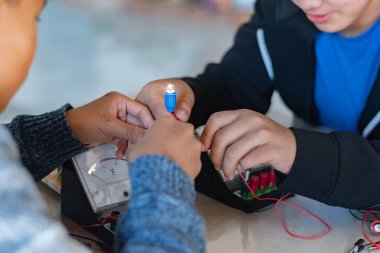 Fizik bilimi dersinde küçük bir elektrik sayacı ve küçük bir fener ampulü kullanarak elektrik devreleri üzerinde deneyler yapmak.