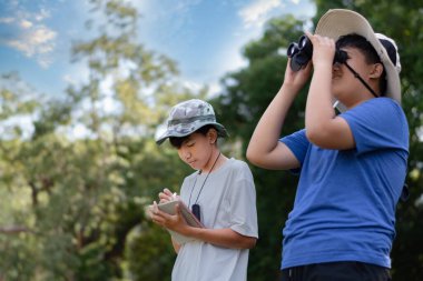 Dürbün, açık havada öğrenme, merak ve çocukluk macerasını yeşil, orman benzeri bir ortamda kullanarak doğayı keşfeden iki Asyalı çocuk..
