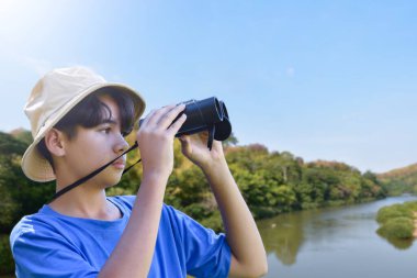 Dürbün, açık hava öğrenimi, merak ve çocukluk macerasını yeşil, orman benzeri bir ortamda kullanarak doğayı keşfeden Asyalı bir çocuk..